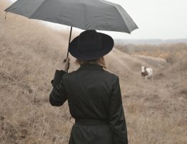 Frau mit Schirm am Strand