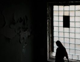 Person Frau vor Fenster Düster
